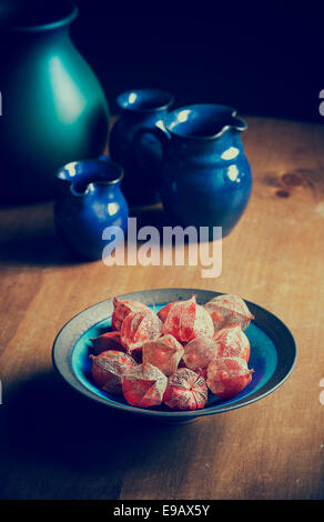 Physalis alkekengi. Lanternes chinoises de séchage des graines de fleurs dans un bol sur une table en bois. Vintage filtre appliqué Banque D'Images