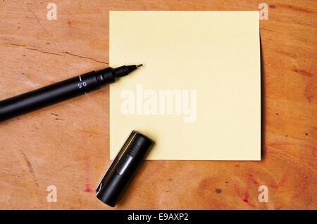 Sticky note avec stylo noir sur planche de bois Banque D'Images