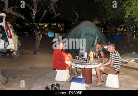 Mère de deux adolescents sur un camping en face d'une tente, la Namibie, Halali Banque D'Images