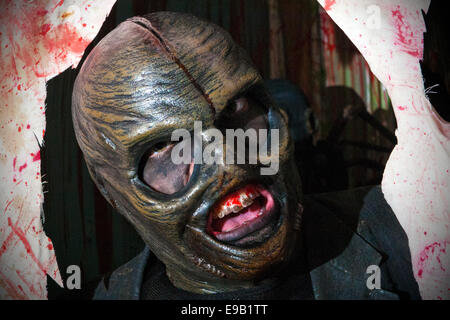 Blackburn, Royaume-Uni. 22 octobre, 2014. Et l'Halloween horreur masqués personnages costumés en masque latex préparer pour terrifier les visiteurs d'effrayer Royaume Scream Park attraction de l'événement nocturne Halloween Horror Nights 2014. Costume et maquillage- Unsettlingly aperçu effrayant dans leur propre droit, jusqu'à 50 acteurs en costumes et maquillage du visage complet offrent une pleine nuit de frissons, de sensations fortes, de terreur et de divertissement dans les locaux près de Preston dans le Lancashire, Royaume-Uni. Credit : Cernan Elias/Alamy Live News Banque D'Images