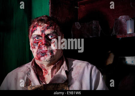 Blackburn, Royaume-Uni. 22 octobre, 2014. Et l'Halloween horreur masqués personnages costumés en masque latex préparer pour terrifier les visiteurs d'effrayer Royaume Scream Park attraction de l'événement nocturne Halloween Horror Nights 2014. Costume et maquillage- Unsettlingly aperçu effrayant dans leur propre droit, jusqu'à 50 acteurs en costumes et maquillage du visage complet offrent une pleine nuit de frissons, de sensations fortes, de terreur et de divertissement dans les locaux près de Preston dans le Lancashire, Royaume-Uni. Credit : Cernan Elias/Alamy Live News Banque D'Images