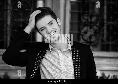 Portrait noir et blanc d'un beau jeune homme souriant Banque D'Images