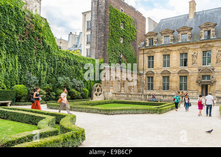 Les touristes dans le jardin de l'Hôtel de Sully, de la place des Vosges, quartier du Marais, Paris, ile de france, france Banque D'Images