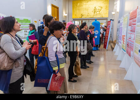 Paris, France. Salon médical, réunion de la SFLS, Société française de lutte contre le SIDA, N.G.O. et sociétés pharmaceutiques. Femmes lisant la recherche regardant les affiches sur le mur dans Hall, scientifiques partageant la recherche sur le vih SIDA, exposition internationale de paris Banque D'Images