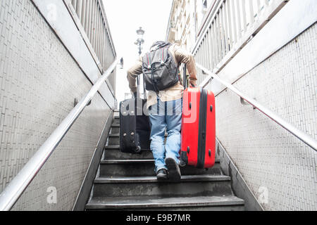 Femme,homme,Guy,mal,avec,filets,et,si,la sortie de métro tout en portant de gros sacs/valises,assurance,en haut d'un escalier à Paris, France. Banque D'Images