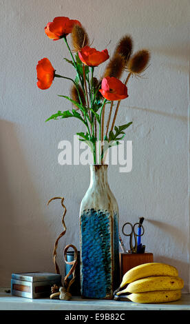 Still Life de coquelicots dans un vase bleu de la banane et des chardons Banque D'Images