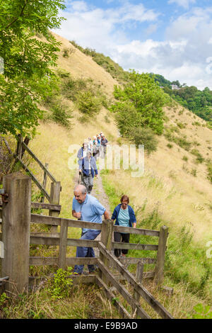 Un groupe de marcheurs âgés marchant sur un chemin à flanc de colline à Upperdale, Derbyshire, Pic Blanc, parc national de Peak District, England, UK Banque D'Images