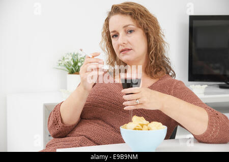 Femme Cigarette tandis que boire du vin et manger des collations Banque D'Images