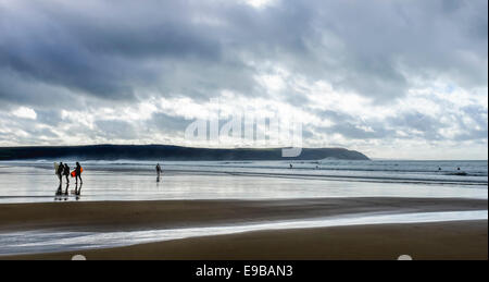 La paix et la tranquillité avec les surfers sur une plage de Woolacombe Sands orageux, North Devon, Angleterre. Banque D'Images