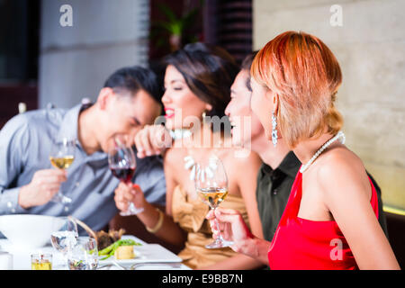 Les amis de l'Asie, deux couples, dîner dans un restaurant de fantaisie manger de la bonne nourriture et de boire du vin Banque D'Images