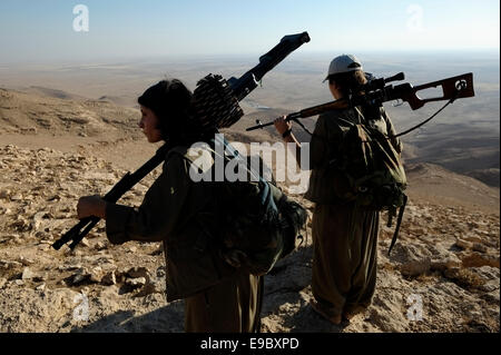 Un groupe de femmes des combattants kurdes des unités pour femmes libres raccourcie en YJA STAR l'aile militaire des femmes du Parti des Travailleurs du Kurdistan PKK lourdement armés à pied dans une zone montagneuse dans la campagne de Makhmur près de Mossoul dans le Nord de l'Irak Banque D'Images