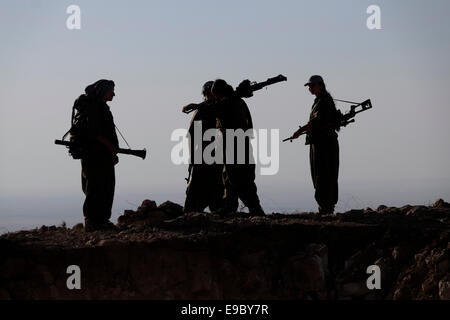 Un groupe de femmes des combattants kurdes des unités pour femmes libres raccourcie en YJA STAR l'aile militaire des femmes du Parti des Travailleurs du Kurdistan PKK lourdement armés stand dans une zone montagneuse dans la campagne de Makhmur près de Mossoul dans le Nord de l'Irak Banque D'Images