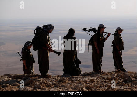 Un groupe de femmes des combattants kurdes des unités pour femmes libres raccourcie en YJA STAR l'aile militaire des femmes du Parti des Travailleurs du Kurdistan PKK lourdement armés stand dans une zone montagneuse dans la campagne de Makhmur près de Mossoul dans le Nord de l'Irak Banque D'Images