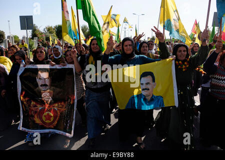 Les femmes kurdes holding flags avec la figure d'Abdullah Ocalan, membre fondateur de l'organisation militante du Parti des Travailleurs du Kurdistan ou PKK lors d'un rassemblement à l'appui de Kurdes syriens souffrant d'ISIS les attaques dans la ville syrienne de Kobane dans la ville d'Erbil Arbil Irbil, aussi orthographié ou la capitale de la région du Kurdistan dans le nord de l'Iraq. Banque D'Images