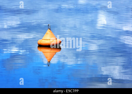 Bouée orange flottant sur l'eau Banque D'Images