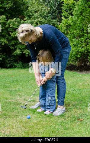 Grand-mère jouant avec toy golf petite-fille de deux ans. UK Banque D'Images