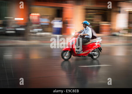 HANOI, VIETNAM - 7 décembre : Man riding scooter sous la pluie. Moyens de transport les plus populaires. Banque D'Images