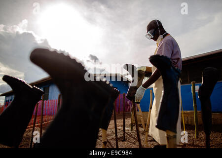 Un travailleur de la santé matériel de protection utilisé nettoie avec les victimes d'Ebola au Corps Médical International clinic 7 Octobre, 2014 dans Suakoko, au Libéria. Banque D'Images