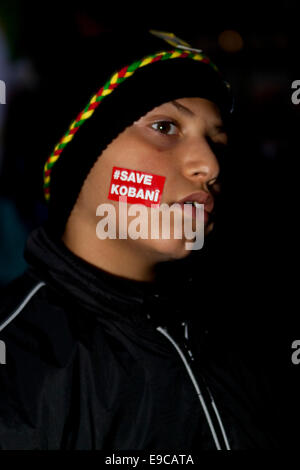 Copenhague, Danemark. 24 Oct, 2014. Garçon kurde avec un tatouage à l'appui de son peuple qui souffre dans la ville déchirée par la guerre de Kobani. Il est décrit comme il en même temps que son père participe à un rassemblement de solidarité kurde contre l'Etat islamique et appelant à la Turquie d'ouvrir ses frontières aux combattants kurdes et les secours d'urgence Crédit : OJPHOTOS/Alamy Live News Banque D'Images