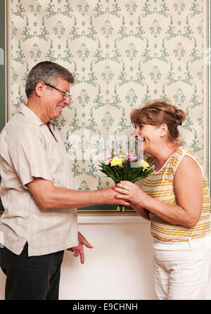 Homme plus âgé donnant femme bouquet de fleurs Banque D'Images