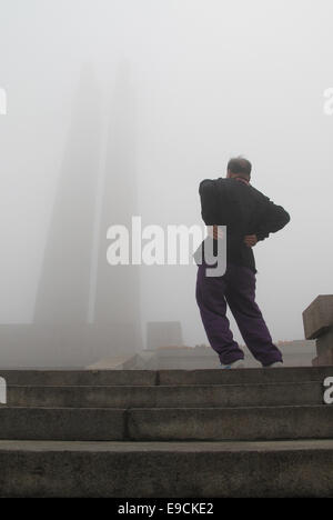 Tangshan, Province de Hebei en Chine. 25 octobre, 2014. Wang Jiang, 78, dose matin des exercices dans un smog-enveloppé square dans la ville de Tangshan, Province de Hebei en Chine du nord, le 25 octobre 2014. Credit : Zheng Yong/Xinhua/Alamy Live News Banque D'Images