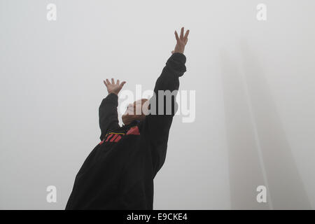 Tangshan, Province de Hebei en Chine. 25 octobre, 2014. Wang Jiang, 78, dose matin des exercices dans un smog-enveloppé square dans la ville de Tangshan, Province de Hebei en Chine du nord, le 25 octobre 2014. Credit : Zheng Yong/Xinhua/Alamy Live News Banque D'Images