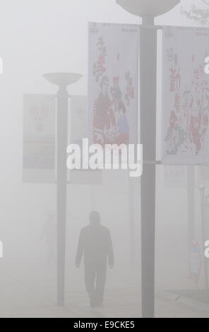 Tangshan, Province de Hebei en Chine. 25 octobre, 2014. Un homme marche à un carré de smog, enveloppé dans la ville de Tangshan, Province de Hebei en Chine du nord, le 25 octobre 2014. Credit : Zheng Yong/Xinhua/Alamy Live News Banque D'Images