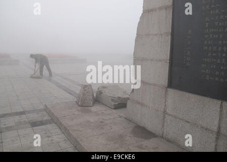 Tangshan, Province de Hebei en Chine. 25 octobre, 2014. Un travailleur de l'assainissement ouvre la voie à un carré de smog, enveloppé dans la ville de Tangshan, Province de Hebei en Chine du nord, le 25 octobre 2014. Credit : Zheng Yong/Xinhua/Alamy Live News Banque D'Images