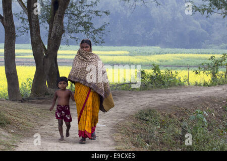 Munshigonj, au Bangladesh. 2 Jan, 2012. Un bengoli femmes avec son enfant marche sur route, dans un village du Bangladesh.La vie dans un village du Bangladesh est, en règle générale, terne et monotone. Les gens du village sont simples, religieux et conservateur. Ils n'aiment pas changer avec l'évolution de l'état du monde. Cette attitude présente un contraste frappant avec la vie dans la ville. Les villageois peuvent être classées sous trois principaux chefs-les riches, la classe moyenne et à la classe ouvrière et les pauvres. Les riches en général, les gens quittent le village et se rendent dans la ville pour profiter de ses multiples avantages. La classe moyenne Banque D'Images