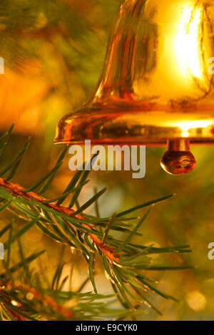 Une clochette d'or est suspendu à l'arbre de Noël. Banque D'Images