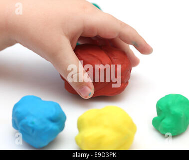 Prendre la main de l'enfant boule d'argile rouge en plastique. Arrière-plan blanc. Banque D'Images
