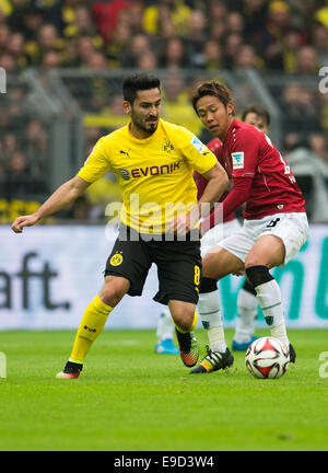 Dortmund, Allemagne. 25 octobre, 2014. Ilkay Guendogan Dortmunds (L) et du Hanovre Hiroshi Kiyotake rivalisent pour le ballon pendant le match de football Bundesliga allemande entre Borussia Dortmund et Hanovre 96 au Signal Iduna Park de Dortmund, Allemagne, 25 octobre 2014. Photo : BERND THISSEN (CONDITIONS DE L'EMBARGO- ATTENTION : En raison de la lignes directrices d'accréditation, le LDF n'autorise la publication et l'utilisation de jusqu'à 15 photos par correspondance sur internet et dans les médias en ligne pendant le match.)/dpa/Alamy Live News Banque D'Images