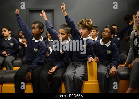 Enfants garçons de l'école mettant les mains jusqu'à l'école primaire élèves UK Woden Banque D'Images