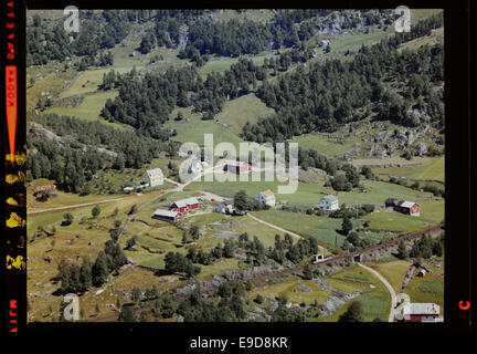Cette photographie aérienne capture la municipalité de Kvinesdal en Norvège, montrant son paysage vu d'en haut. Il fait partie de la collection Nasjonalbiblioteket, prise par Flyveselskap A/S. de Widerøe Banque D'Images