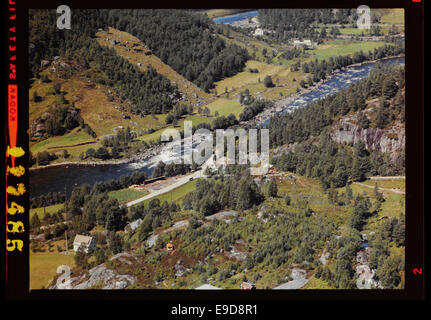 Cette photographie aérienne montre la municipalité de Kvinesdal, capturant le paysage et l'aménagement urbain de la région. La photo, prise par Flyveselskap A/S de Widerøe, offre une vue historique de la région. Banque D'Images