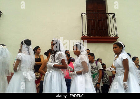 (141026) -- SUCHITOTO, 26 octobre 2014 (Xinhua) -- Les filles accompagnés par leur chef de famille pour célébrer leur première Eucharistie, dans l'église de Santa Lucia, dans la ville de Suchitoto, Cuscatlan ministère, 47 kilomètres au nord de San Salvador, capitale du Salvador, le 25 octobre 2014. Autour de 300 enfants, la plupart provenant de différentes communautés rurales, ont à se préparer à une année pour célébrer collectivement leur première eucharistie. (Xinhua/Oscar Rivera) (lmz) Banque D'Images