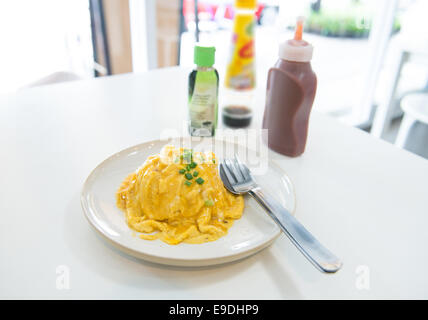 Omelette crémeuse sur le riz en plaque blanche sur la table Banque D'Images