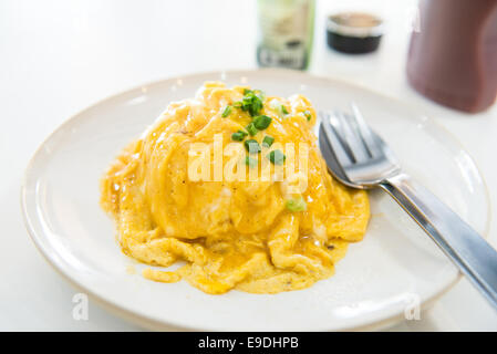 Omelette crémeuse sur le riz en plaque blanche Banque D'Images