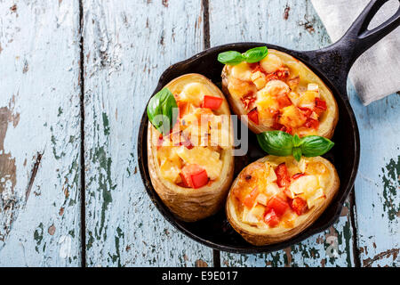 Pommes de terre farcies de fromage et les tomates dans une casserole Banque D'Images