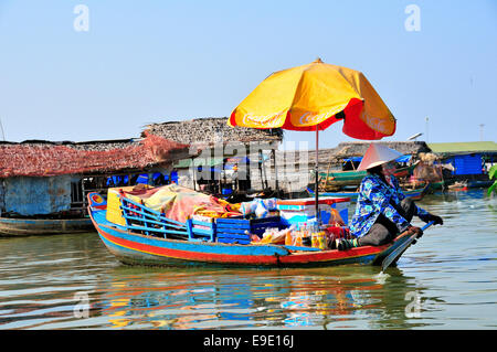 Femme vendant les marchandises avec un parasol sur le bateau sur le lac Tonle Sap, au Cambodge, en Asie du Sud-Est, l'Indochine Banque D'Images