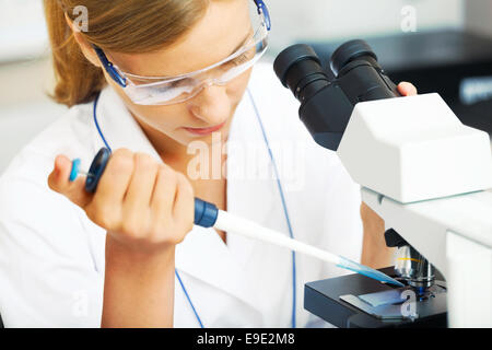 Belle femme dans un laboratoire avec un microscope. Banque D'Images