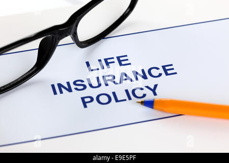La politique d'assurance-vie avec des lunettes et stylo à bille. Banque D'Images