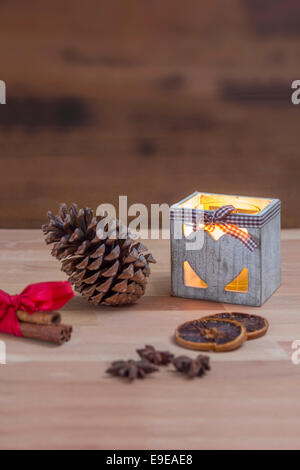 Fir Cone avec une bougie cannelle oranges séchées et d'anis étoilé sur une table en bois Banque D'Images