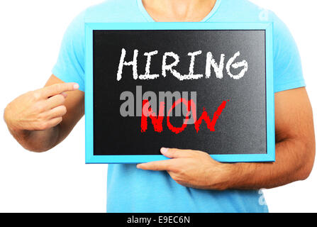 Man holding tableau noir dans les mains et en pointant le mot maintenant embauche Banque D'Images