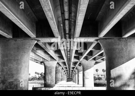 Vue sur le dessous de l'Ouest Mission Bay Dr Bridge. Les colonnes en béton en noir et blanc. San Diego, Californie. Banque D'Images