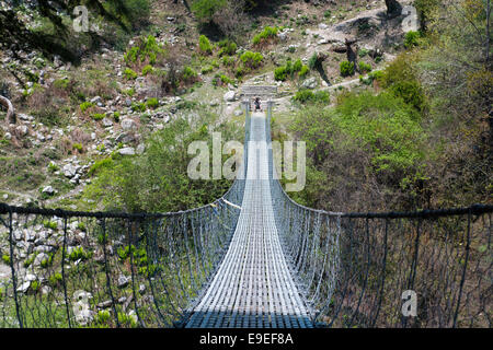 Pont suspendu sur le circuit de l'Annapurna - les touristes les plus populaires de la randonnée en montagne de l'Himalaya au Népal massive. Banque D'Images