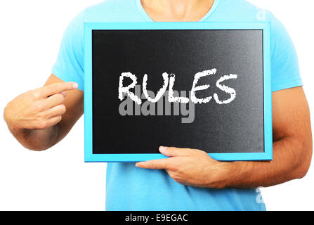 Man holding tableau noir dans les mains et en pointant le mot Règles Banque D'Images