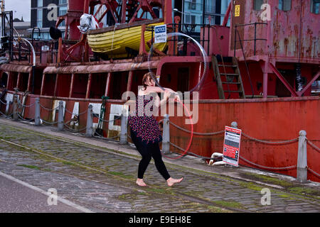 Claire Nicoll Hula Hoop windy dansant sur une après-midi d'octobre à côté de l'Amérique du Carr à l'état lège Victoria Docks à Dundee, Royaume-Uni Banque D'Images