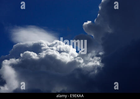 L'image expressive de ciel bleu profond et les nuages éclairés par le soleil invisible Banque D'Images