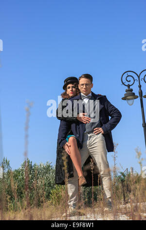 La mode vintage couple debout à l'extérieur de style romantique portant des manteaux par le lampadaire Banque D'Images